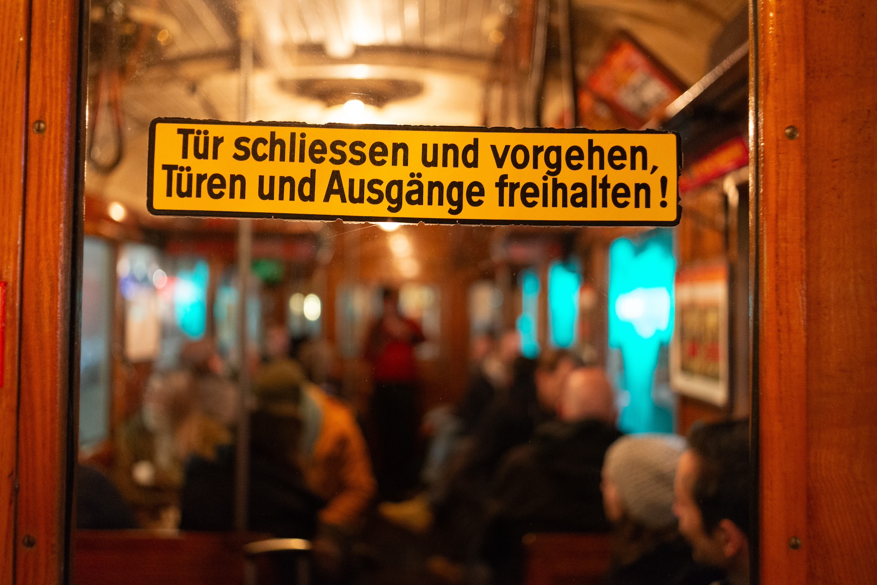 A sign on the door of a tram stating to keep clear of the doors.